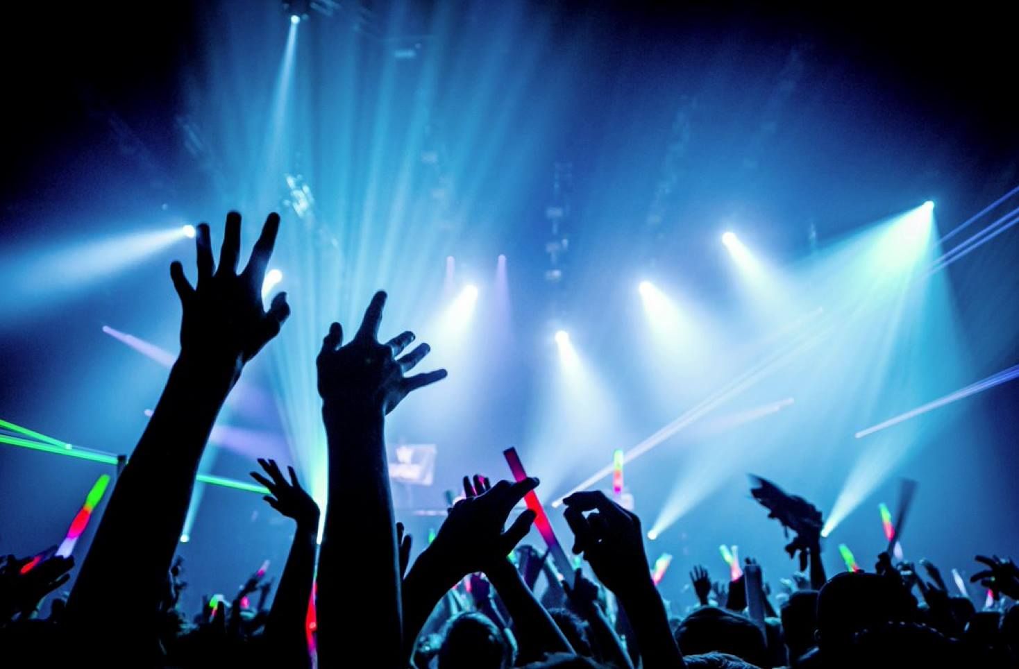 People at a rave with their hands in the air